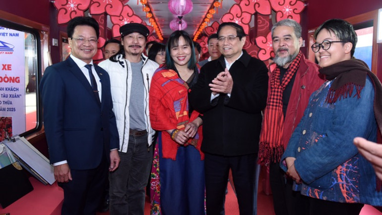 Thủ tướng Phạm Minh Chính với các nghệ sĩ, hoạ sĩ đi theo phục vụ hành khách trên "Chuyến tàu Xuân". (Ảnh: TRẦN HẢI)