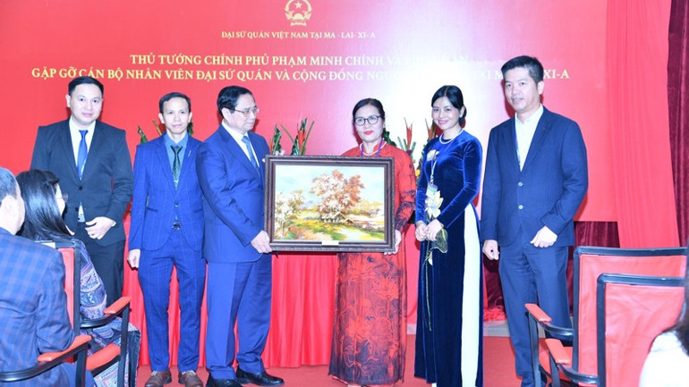 Thủ tướng Phạm Minh Chính tặng quà lưu niệm cho cộng đồng người Việt Nam tại Malaysia.(Ảnh: THANH GIANG) Thủ tướng Phạm Minh Chính tặng quà lưu niệm cho cộng đồng người Việt Nam tại Malaysia.(Ảnh: THANH GIANG)