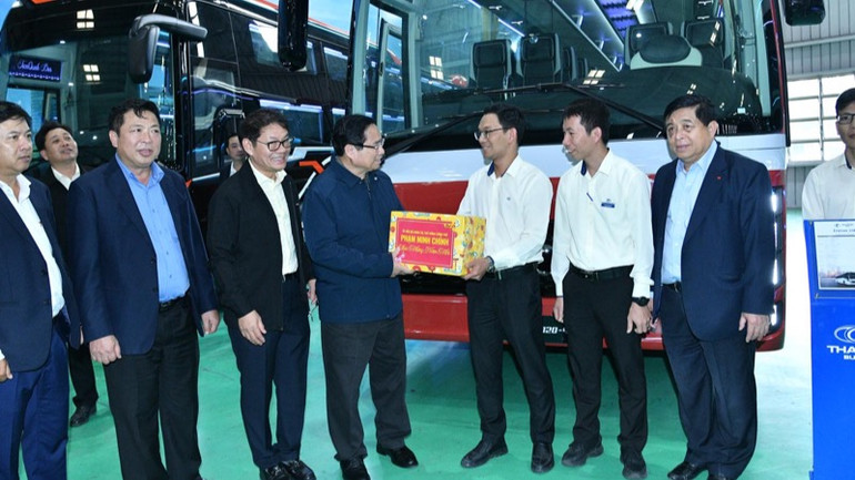 Thủ tướng Phạm Minh Chính tặng quà động viên người lao động của Tập đoàn THACO. (Ảnh: THANH GIANG)