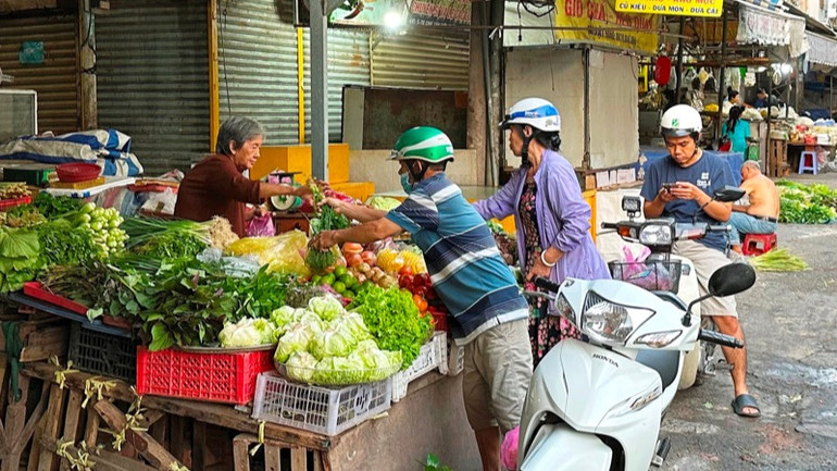 Người dân mua rau, củ, quả ở chợ Tân Sơn Nhất trong sáng 1/2. (Ảnh: HOÀNG LIÊM)