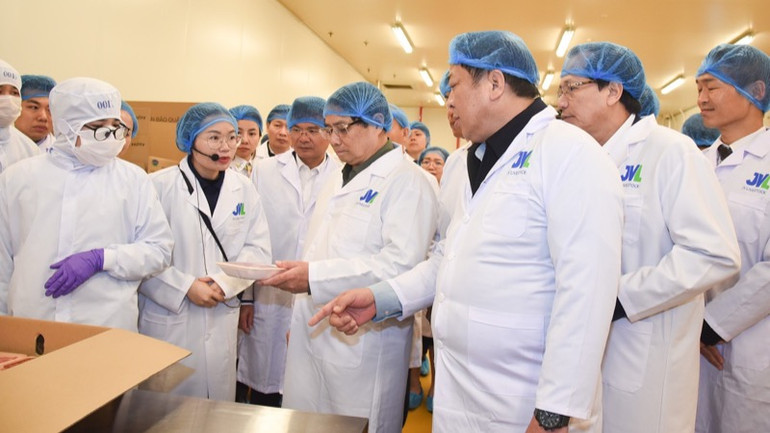 Thủ tướng Phạm MInh Chính nghe giới thiệu về thành phẩm thịt bò chuẩn bị xuất xưởng. (Ảnh: TRẦN HẢI)