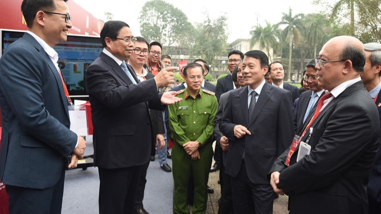 Thủ tướng Phạm Minh Chính trao đổi với các đồng chí lãnh đạo sau khi trải nghiệm các dịch vụ công dựa trên các nền tảng số (Ảnh: TRẦN HẢI).