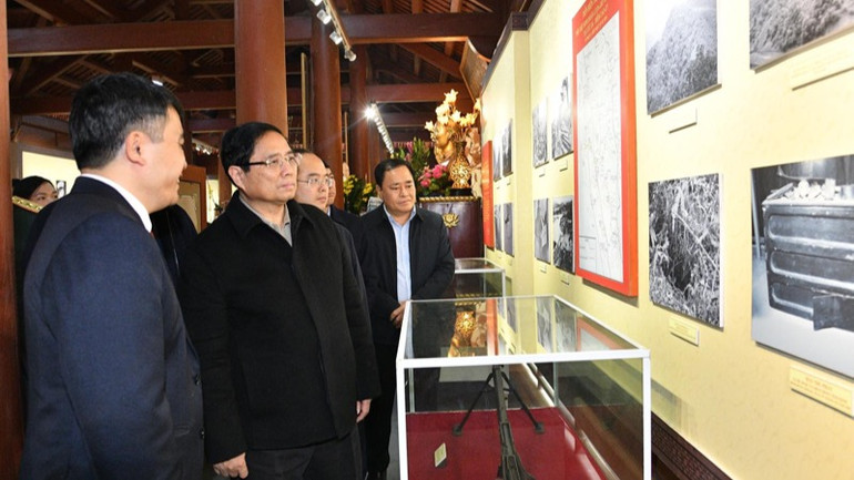 Thủ tướng Phạm Minh Chính nghe giới thiệu về các tư liệu, hiện vật trưng bày trong Nhà tưởng niệm Chủ tịch Hồ Chí Minh. (Ảnh: THANH GIANG)