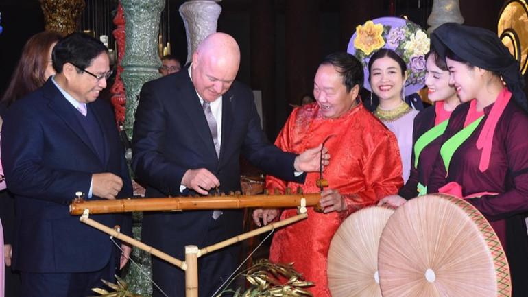 Thủ tướng New Zealand Christopher Luxon trải nghiệm nhạc cụ đàn bầu làm bằng thân tre. (Ảnh: TRẦN HẢI)