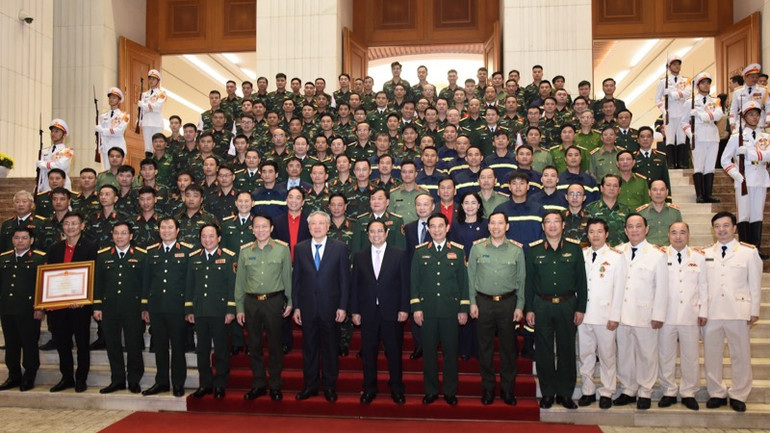 Thủ tướng Phạm Minh Chính, các đồng chí lãnh đạo chụp ảnh lưu niệm cùng đoàn công tác cứu hộ, cứu nạn của lực lượng Quân đội và Công an. (Ảnh: TRẦN HẢI)