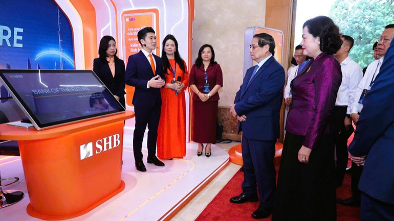 Lãnh đạo Ngân hàng SHB giới thiệu với Thủ tướng Phạm Minh Chính về những dịch vụ, tiện ích thông minh của ngân hàng. (Ảnh: TRẦN HẢI) Lãnh đạo Ngân hàng SHB giới thiệu với Thủ tướng Phạm Minh Chính về những dịch vụ, tiện ích thông minh của ngân hàng. (Ảnh: TRẦN HẢI)