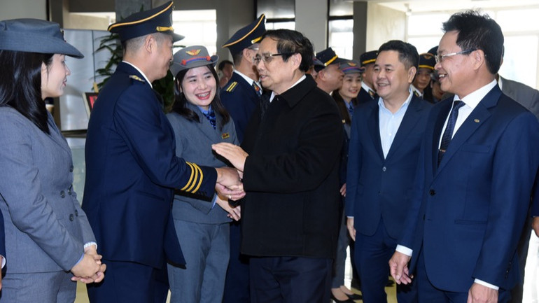 Thủ tướng Phạm Minh Chính hỏi thăm cán bộ, nhân viên ngành đường sắt Việt Nam phục vụ các chuyến tàu dịp Tết tại ga Hà Nội. (Ảnh: TRẦN HẢI)