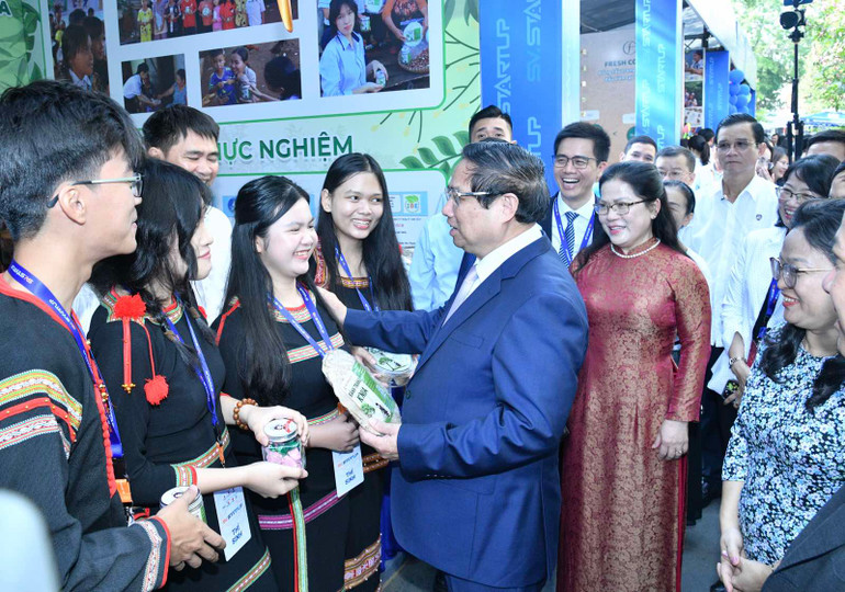 Thủ tướng Phạm Minh Chính tìm hiểu sản phẩm của một nhóm học sinh (Ảnh: THANH GIANG).