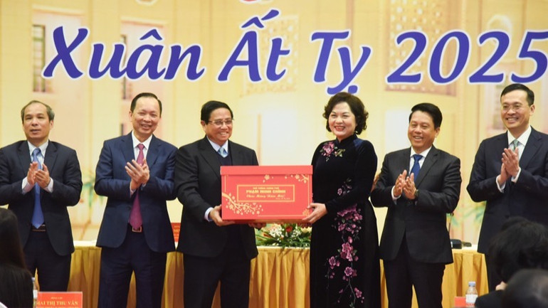 Thủ tướng Phạm Minh Chính tặng quà chúc mừng ngành Ngân hàng. (Ảnh: TRẦN HẢI)