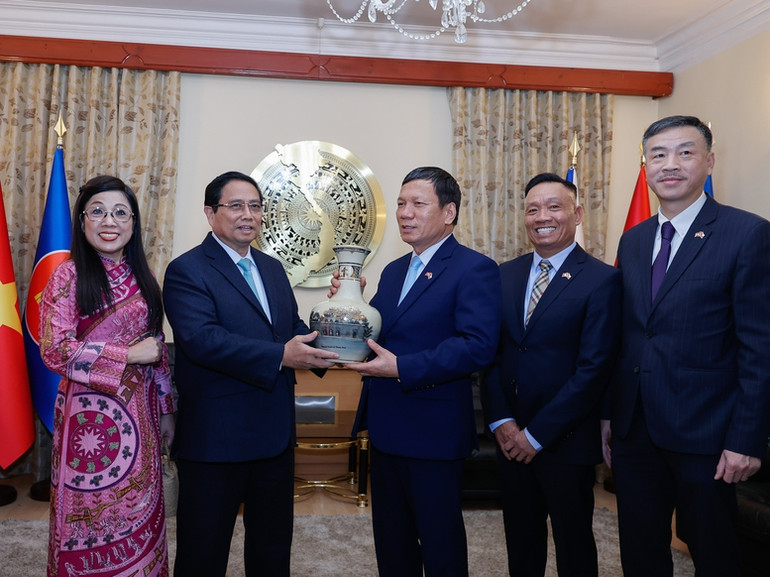 Thủ tướng Phạm Minh Chính tặng quà lưu niệm cho Liên hiệp Hội người Việt Nam tại châu Âu và Czech. (Ảnh: NHẬT BẮC/VGP)