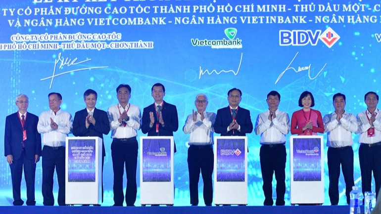 Lãnh đạo tỉnh Bình Dương chứng kiến nghi thức ký thỏa thuận tín dụng tài trợ cho dự án cao tốc. (Ảnh: THANH GIANG)