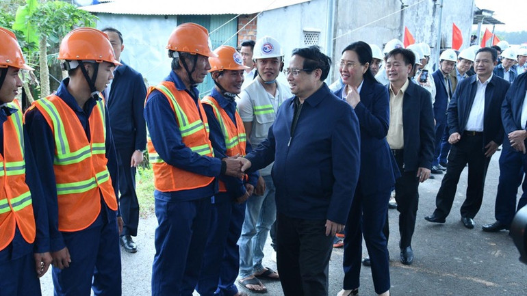 Thủ tướng Phạm Minh Chính thăm hỏi, động viên các kỹ sư, công nhân đang thi công tuyến đường. (Ảnh: THANH GIANG)