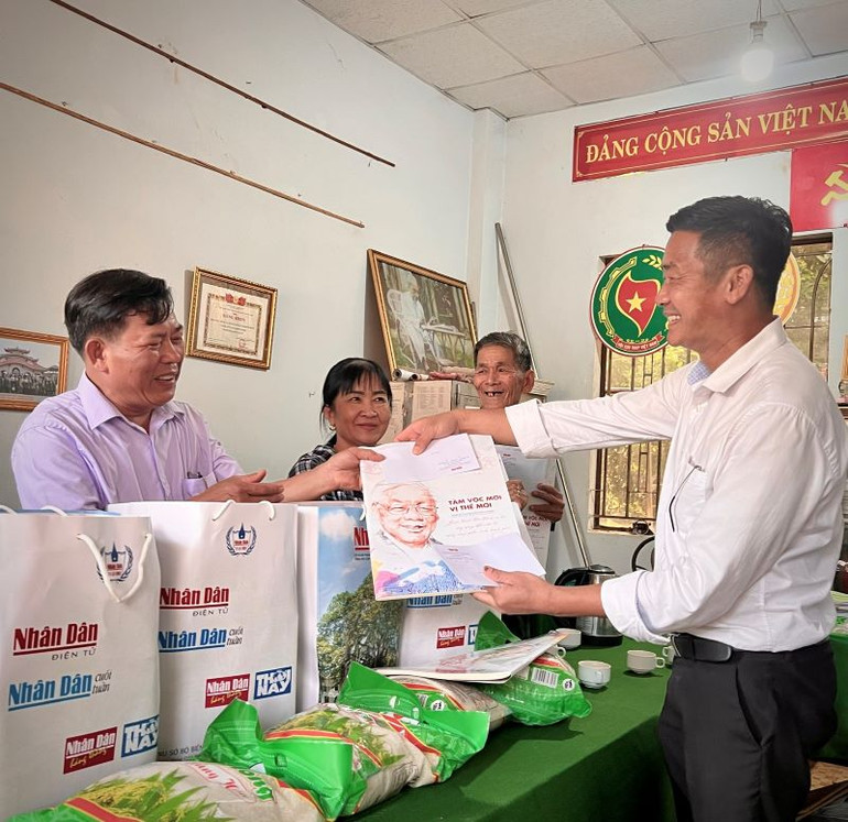 Đại diện Văn phòng Báo Nhân Dân tại Bình Phước tặng quà cho các gia đình có công với cách mạng tại xã Phước An, huyện Hớn Quản.