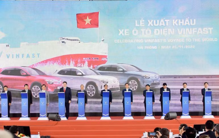 Thủ tướng Phạm Minh Chính và các đại biểu thực hiện nghi thức bấm nút phát lệnh xuất khẩu lô xe ô-tô điện đầu tiên của Vinfast.