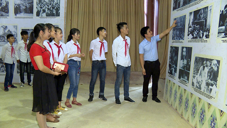 Các em học sinh nghe giới thiệu về những hình ảnh lịch sử tại Đại hội II.