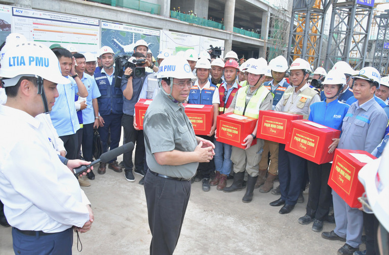 Thủ tướng Phạm Minh Chính tặng quà động viên, ân cần thăm hỏi kỹ sư, công nhân đang hăng say lao động trên công trường. (Ảnh: THANH GIANG)