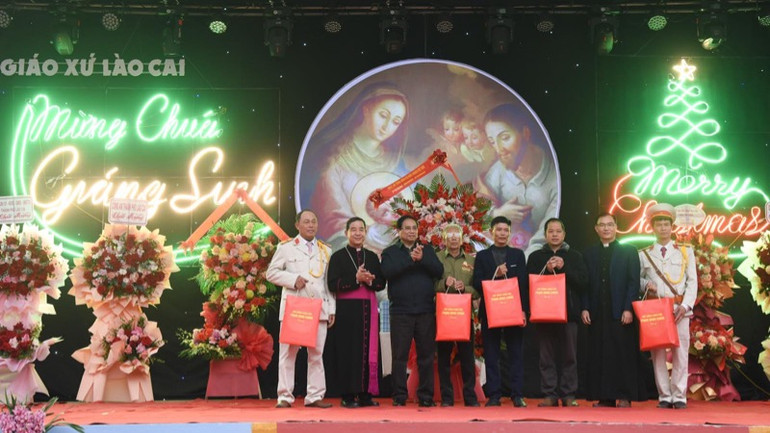 Thủ tướng Phạm Minh Chính tặng quà chúc mừng Giáng sinh cho một số giáo dân Giáo xứ Lào Cai. (Ảnh: TRẦN HẢI)