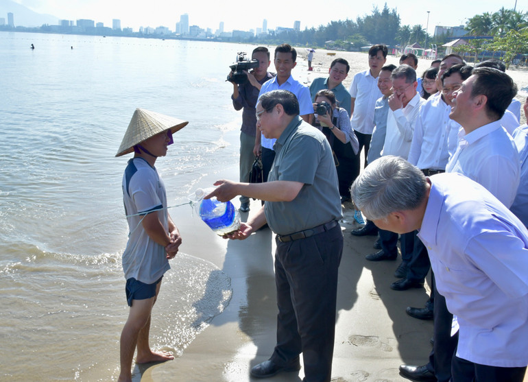 Thủ tướng Phạm Minh Chính hỏi thăm một người đánh bắt hải sản trên bãi biển. (Ảnh: THANH GIANG) Thủ tướng Phạm Minh Chính hỏi thăm một người đánh bắt hải sản trên bãi biển. (Ảnh: THANH GIANG)