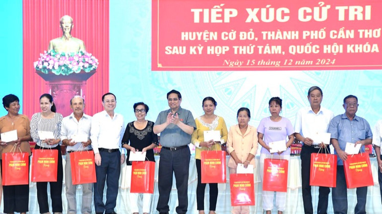 Thủ tướng Phạm Minh Chính tặng quà cho các gia đình chính sách, gia đình thương binh, liệt sĩ gia đình công giáo tiêu biểu trên địa bàn huyện Cờ Đỏ (Ảnh: THANH GIANG).