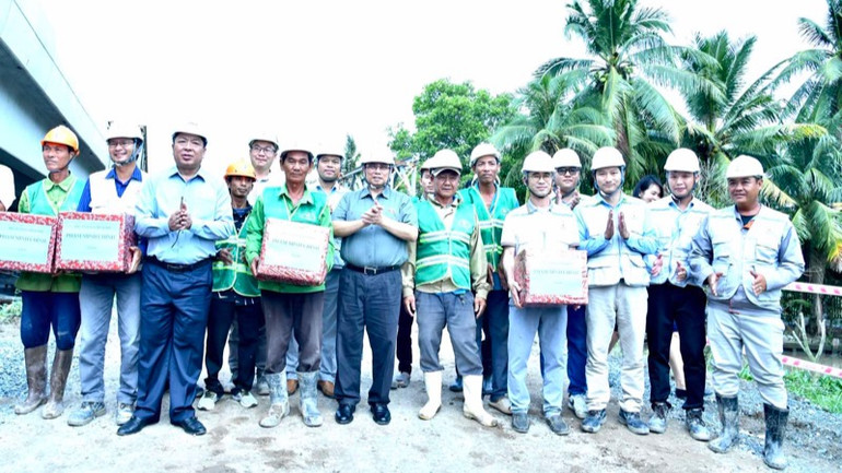 Thủ tướng Phạm Minh Chính tặng quà động viên đội ngũ kỹ sư, công nhân đang thi công tại Nút giao IC4 thuộc Dự án cao tốc Cần Thơ-Cà Mau. (Ảnh: Thanh Giang)