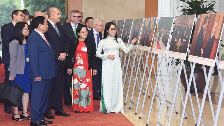 Tổng thống Bulgaria Rumen Radev nghe giới thiệu Triển lãm ảnh quan hệ Việt Nam-Bulgaria. (Ảnh: Trần Hải).