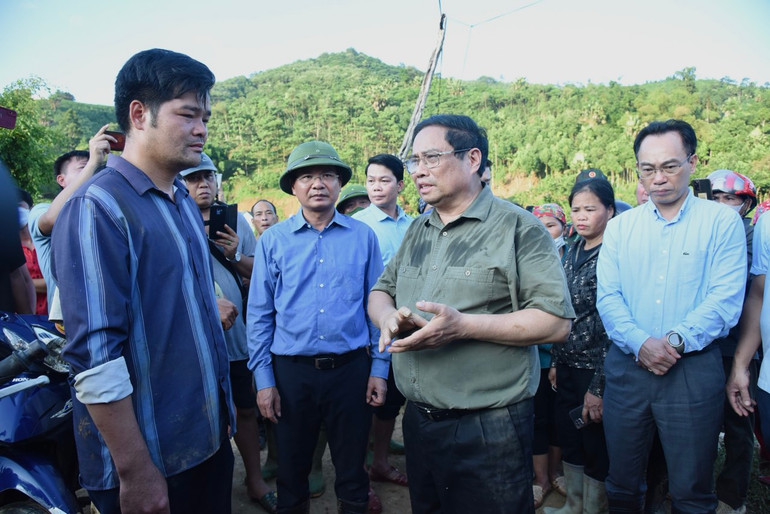 Thủ tướng Phạm Minh Chính thăm hỏi một người dân Làng Nủ có thân nhân thiệt mạng trong trận lũ quét vừa qua. (Ảnh: TRẦN HẢI)