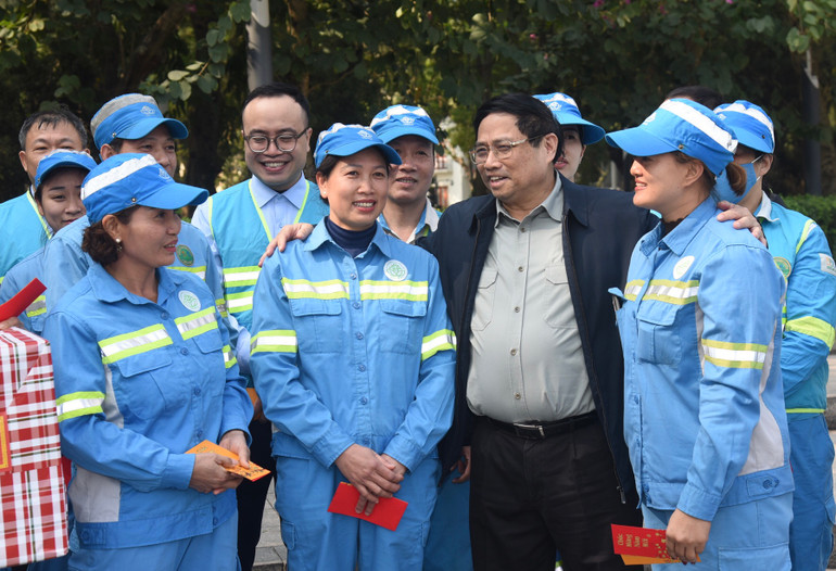Thủ tướng Phạm Minh Chính ân cần thăm hỏi công nhân vệ sinh môi trường của Công ty Môi trường Đô thị Hà Nội đang làm việc tại khu vực Tượng đài Lênin trên đường Điện Biên Phủ. Ảnh: TRẦN HẢI
