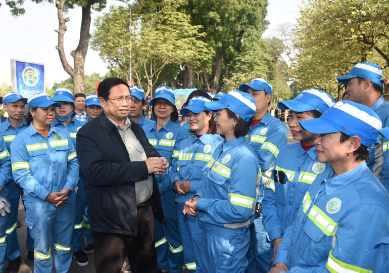 Thủ tướng Phạm Minh Chính thăm hỏi công nhân Tổ vệ sinh môi trường đang làm việc tại khu vực Đài tưởng niệm các Anh hùng liệt sĩ trên đường Hoàng Diệu. Ảnh: TRẦN HẢI