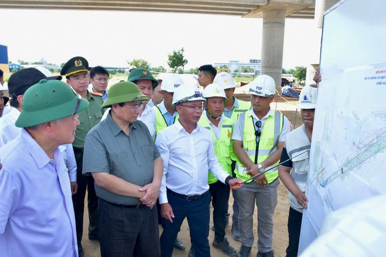 Thủ tướng Phạm Minh Chính nghe báo cáo tiến độ xây dựng công trình. (Ảnh: THANH GIANG) Thủ tướng Phạm Minh Chính nghe báo cáo tiến độ xây dựng công trình. (Ảnh: THANH GIANG)