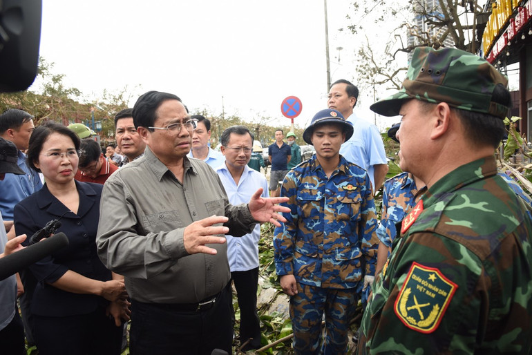 Thủ tướng Phạm Minh Chính thăm hỏi lực lượng Quân đội đang tham gia giúp nhân dân dọn dẹp vệ sinh môi trường ở thành phố Hạ Long (Ảnh: TRẦN HẢI).