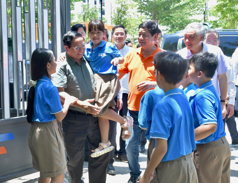 Các cháu học sinh Trường Hy Vọng vui mừng đón Thủ tướng Phạm Minh Chính tại cổng trường. (Ảnh: THANH GIANG)