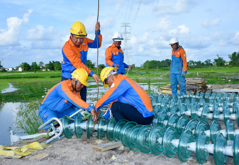 Chuẩn bị sứ cách điện để lắp đặt trên đường dây. (Ảnh:Trần Hải)