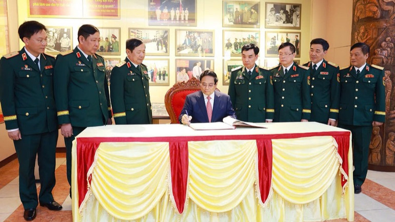 Thủ tướng Phạm Minh Chính ghi lưu bút tại Phòng truyền thống của Học viện Kỹ thuật Quân sự. (Ảnh: TRẦN HẢI)