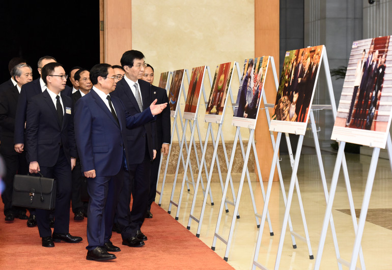 Thủ tướng Phạm Minh Chính giới thiệu với Chủ tịch Chính hiệp toàn quốc Trung Quốc Vương Hộ Ninh triển lãm ảnh về quan hệ Việt Nam-Trung Quốc.