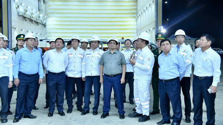 Thủ tướng Phạm Minh Chính tham quan xưởng sơn chân đế điện gió ngoài khơi tại Trung tâm Công nghiệp năng lượng và hậu cần kỹ thuật PTSC. (Ảnh: Thanh Giang)
