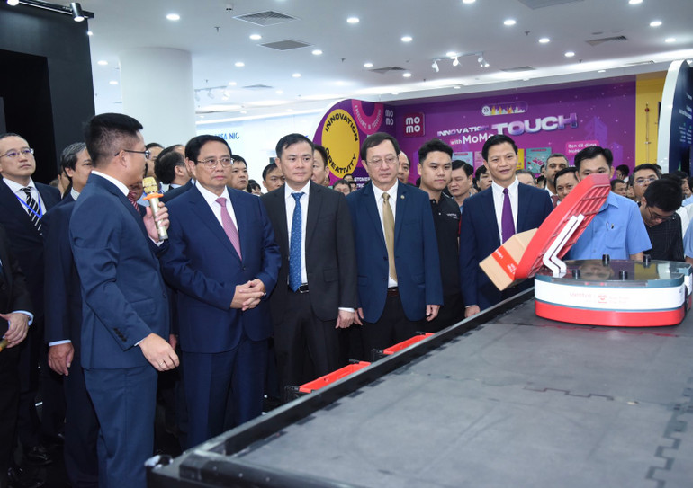 Thủ tướng Phạm Minh Chính trải nghiệm một gian trưng bày về đổi mới sáng tạo. (Ảnh: TRẦN HẢI)