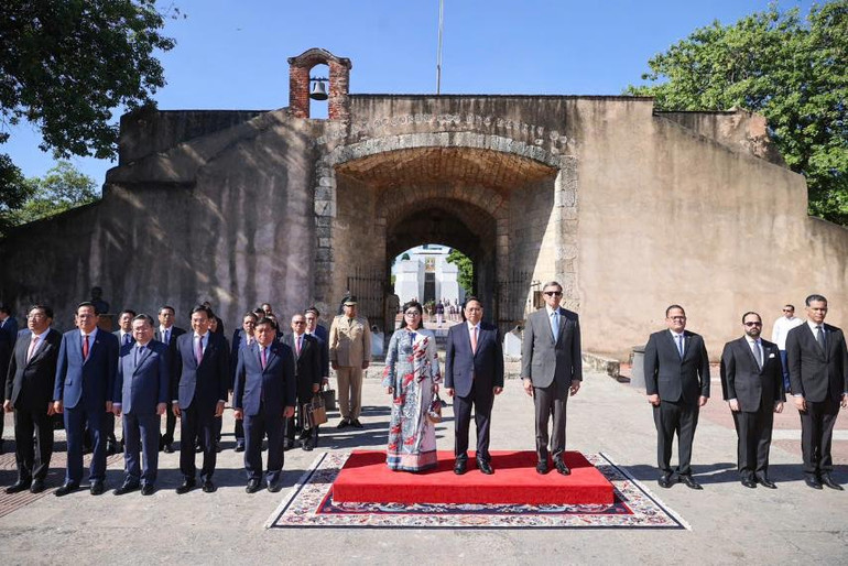 Thủ tướng Phạm Minh Chính và Phu nhân và quan chức CH Dominica đứng trên bục danh dự nghe Đội quân nhạc cử Quốc thiều hai nước. (Ảnh: Nhật Bắc/VGP)