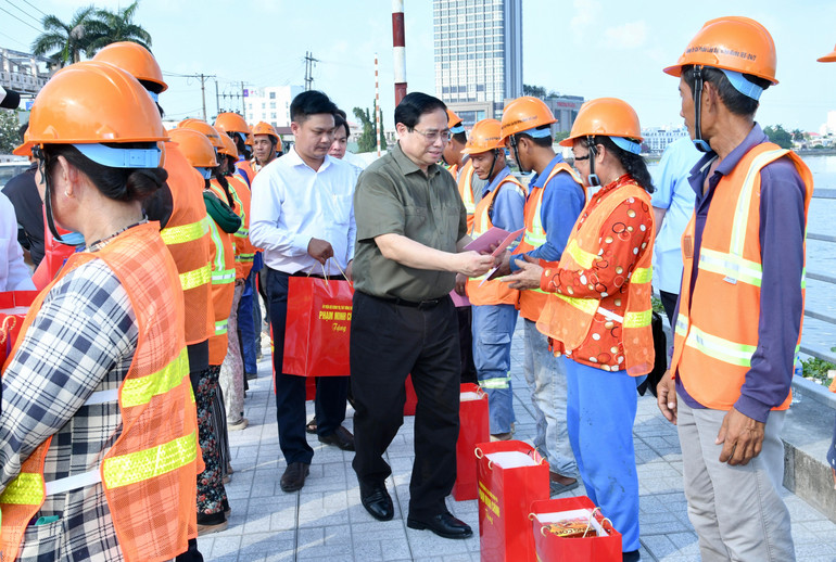 Thủ tướng Phạm Minh Chính tặng quà chúc Tết công nhân đang thi công tuyến đường ven bờ kè sông Hậu trên địa bàn thành phố Cần Thơ.