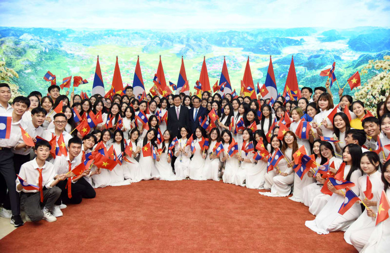 Thủ tướng Phạm Minh Chính và Tổng Bí thư, Chủ tịch nước Lào Thongloun Sisoulith với các thanh niên Việt Nam. (Ảnh:TRẦN HẢI)