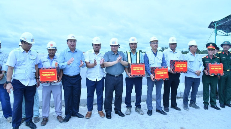 Thủ tướng Phạm Minh Chính tặng quà động viên đội ngũ kỹ sư, công nhân đang thi công tại khu vực Nút giao IC3 trên địa bàn xã Long Thạnh, huyện Phụng Hiệp, tỉnh Hậu Giang (Ảnh: Thanh Giang).