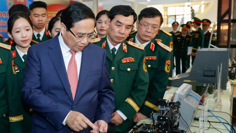 Thủ tướng Phạm Minh Chính tham quan các gian trưng bày sản phẩm, công trình nghiên cứu khoa học của Học viện Kỹ thuật Quân sự. (Ảnh: TRẦN HẢI)