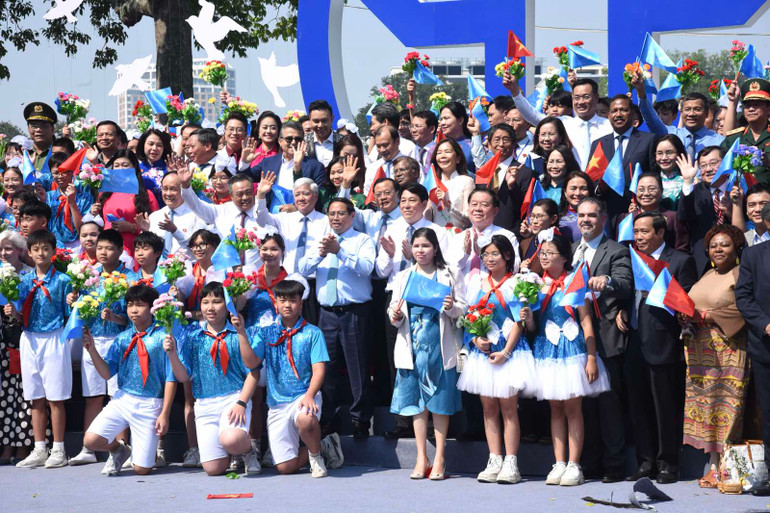 Thủ tướng Phạm Minh Chính, các đồng chí lãnh đạo, đại biểu khách quốc tế chụp ảnh lưu niệm với học sinh Thủ đô tham gia diễu hành. (Ảnh: Trần Hải)