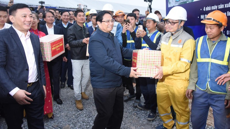 Thủ tướng Phạm Minh Chính tặng quà đội ngũ kỹ sư, công nhân đang thi công dự án nhà ở xã hội Golden Square Lào Cai. (Ảnh: TRẦN HẢI)
