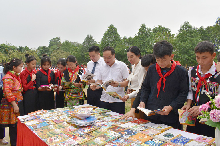 Các đại biểu và học sinh đọc sách tại chương trình.