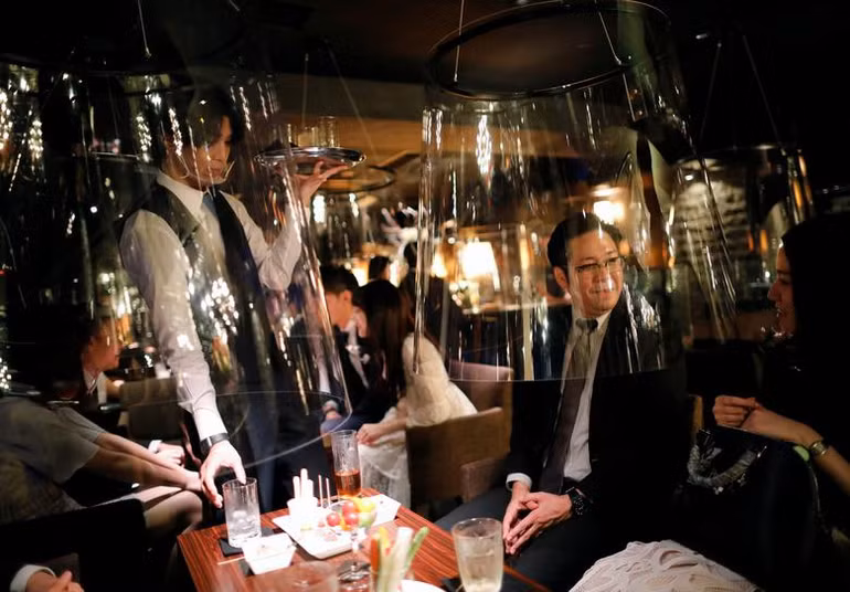 Tấm chắn acrylic được lắp đặt trong một hộp đêm tại Tokyo (Nhật Bản) như một biện pháp giãn cách xã hội. (Ảnh: Reuters)