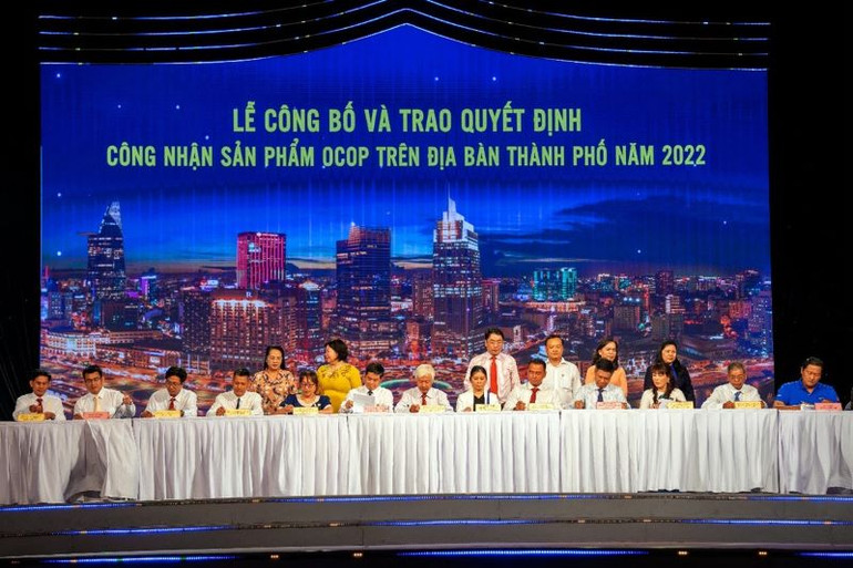 Tổng Giám đốc SATRA Lâm Quốc Thanh (hàng ngồi, thứ sáu, từ trái qua) đã ký biên bản ghi nhớ với các nhà cung cấp đạt Giấy chứng nhận sản phẩm OCOP chuẩn 3 và 4 sao của Ủy ban nhân dân thành phố Hồ Chí Minh 2022.