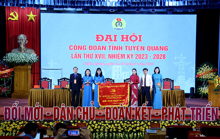 Lãnh đạo tỉnh Tuyên Quang tặng cờ thêu với dòng chữ "Đổi mới, dân chủ, đoàn kết, phát triển" cho lãnh đạo Liên đoàn Lao động tỉnh.