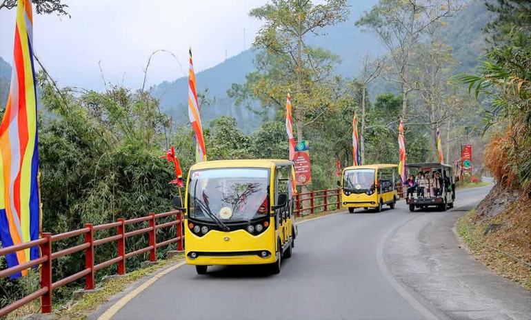 Du khách đi xe điện lên khu vực cáp treo.