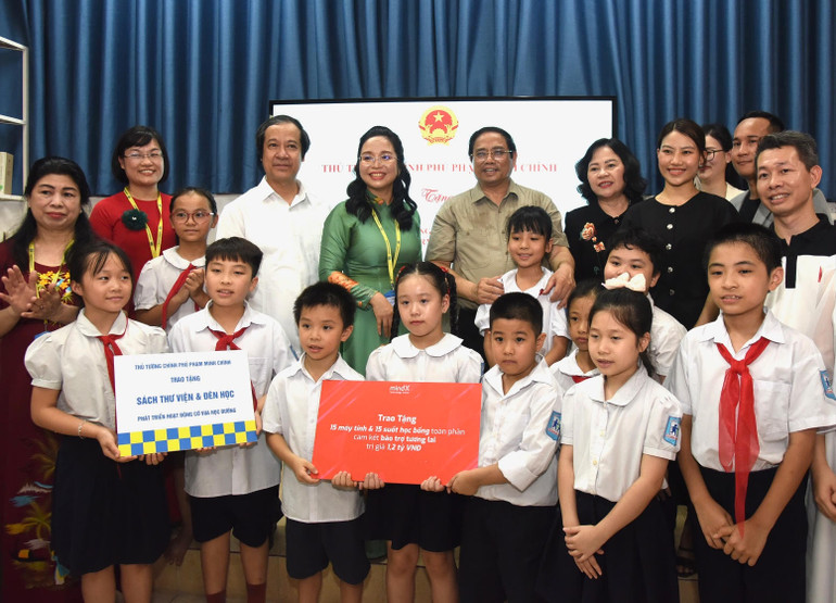 Thủ tướng Phạm Minh Chính tặng quà động viên các cháu học sinh Trường phổ thông dân lập Hermann Gmeiner Hà Nội. (Ảnh: Trần Hải)