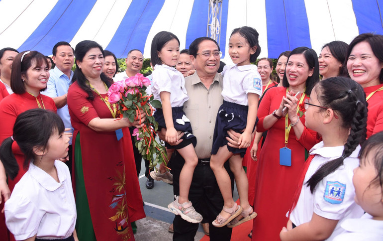 Thủ tướng Phạm Minh Chính và các cháu học sinh Trường phổ thông dân lập Hermann Gmeiner Hà Nội. (Ảnh: Trần Hải)